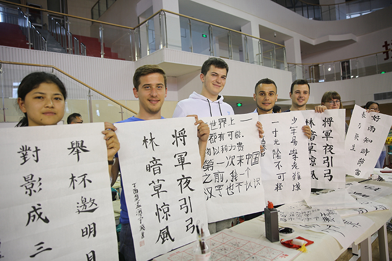 2017年6月5日,来自青岛大学和中国石油大学(华东)的外国留学生在展示刚刚现场完成的书法作品。