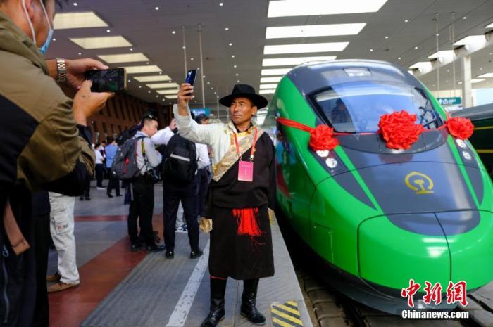 2021年6月25日,川藏铁路拉林段(拉林铁路)正式开通运营,复兴号高原内电双源动车组同步投入运营。拉林铁路全长48公里,设计时速160公里。这是西藏首条电气化铁路,也是复兴号动车组首次开进西藏。图为当日,民众在拉萨火车站复兴号车头前拍照留念。 <a target='_blank' href='/'>中新社</a>记者 江飞波 摄 2021年6月25日,川藏铁路拉林段(拉林铁路)正式开通运营,复兴号高原内电双源动车组同步投入运营。拉林铁路全长48公里,设计时速160公里。这是西藏首条电气化铁路,也是复兴号动车组首次开进西藏。图为当日,民众在拉萨火车站复兴号车头前拍照留念。 <a target='_blank' href='/'>中新社</a>记者 江飞波 摄