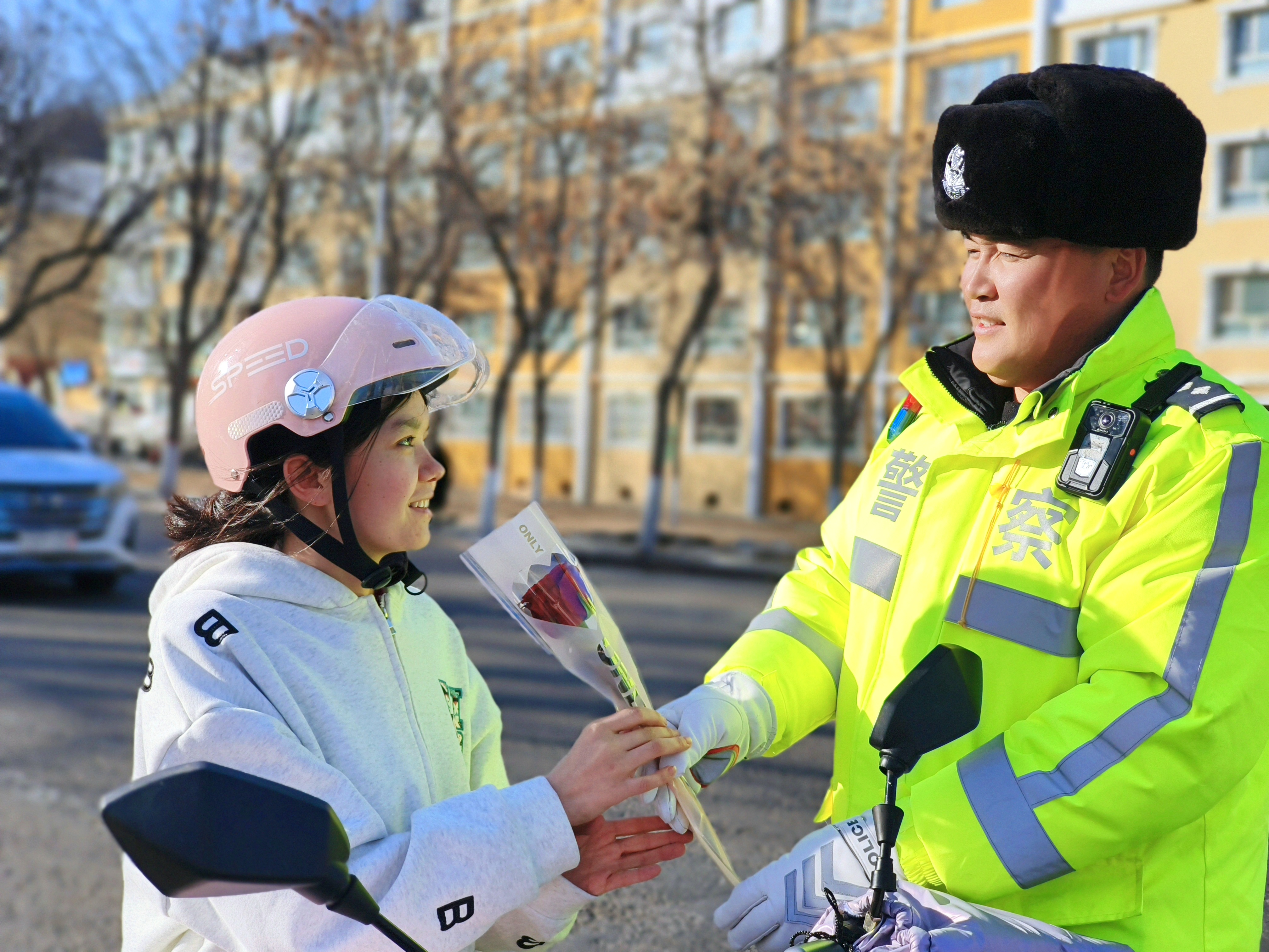 民警为骑行戴好安全头盔的女士送去鲜花.jpg 民警为骑行戴好安全头盔的女士送去鲜花.jpg
